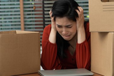 Üzgün Asyalı kadın, işten çıkarıldıktan ve işsiz kaldıktan sonra eşyalarını karton bir kutuya koyup masanın üstünde ağlıyor. Ekonomik kriz ve başarısızlığın yönetimi üzerindeki etki kavramı