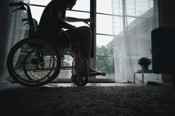 A disabled man sitting in a wheelchair is disappointed and Desperate to heal after car accident. Concept of Careless Driving, Insurance and Mental health care After the accident