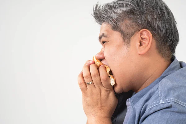 亚洲中年男子 暴食紊乱症 Bed 吃垃圾食品和不健康食品放松 的概念 — 图库照片