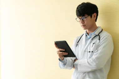 Genç Asyalı doktorlar hastaların sağlık muayenesi için bilgi ve verileri kontrol etmek için tablet kullanıyorlar. Dijital, teknoloji ve tıbbi iletişim kavramı.