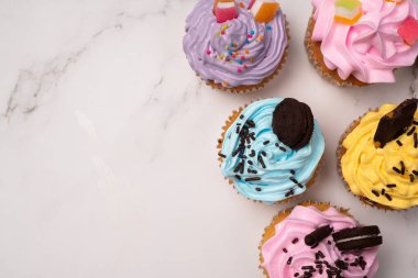 Renkli kremalı ve üzeri şekerli ve çikolatalı kurabiyeli nefis ev yapımı kekler. Ev yapımı sonbahar tatili tatlısı.