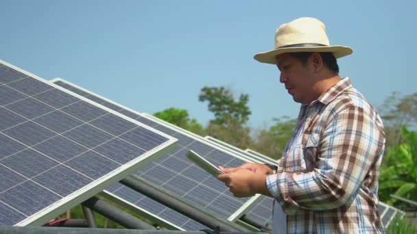 Gli agricoltori asiatici usano compresse per regolare il grado delle celle solari e controllare le prestazioni delle celle solari dopo pioggia e polvere e macchie di sporco sulla cella solare. Concetto di tecnologia agricola. — Video Stock