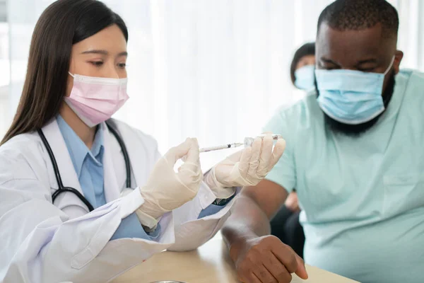 Asiatiske Læge Bruger Sprøjte Kanyle Til Injektion Vaccinere African American Stock-billede