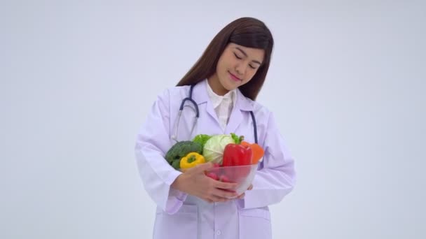 Médico o nutricionista sosteniendo fruta fresca y sonriendo en una clínica. concepto de dieta saludable de los alimentos de nutrición como una receta para la buena salud, la fruta es la medicina — Vídeo de stock