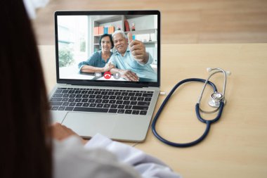 Hastalığın belirtilerini gözlemlemek ve sormak ve sağlık hizmetleri, teletıp ve tele-sağlık konseptine danışmanlık yapmak için yaşlı hastayla doktor çevrimiçi video konferansı.