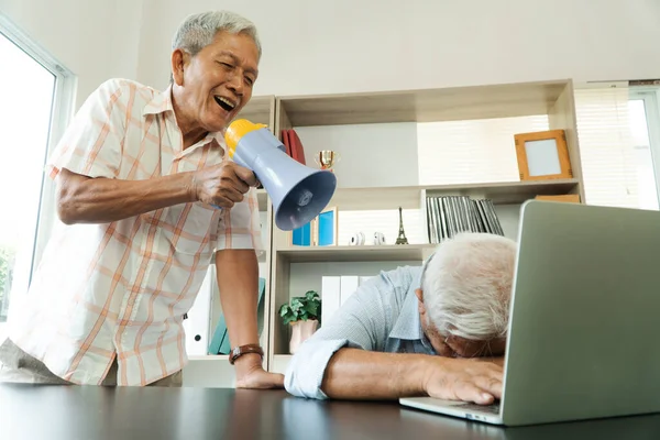 Old Asian elderly yell to a megaphone to talk with a friend for communication. Concept of communication problem in aging cause of ear be without hearing, deaf