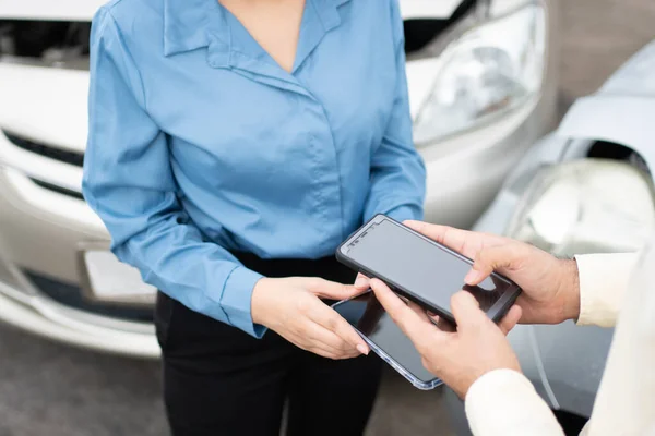 車の事故後に電話番号とソーシャルメディアを交換するためにスマートフォンを使用して2人のドライバー 保険会社に写真や証拠を送信した後 オンライン自動車事故のための請求保険の概念 — ストック写真