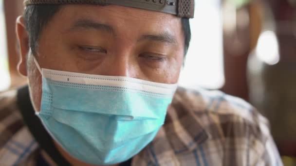 Close-up portret van de man van middelbare leeftijd met een medisch masker en kijkend naar de camera, het Coronavirus COVID-19 en het concept van de bescherming tegen luchtverontreiniging. — Stockvideo