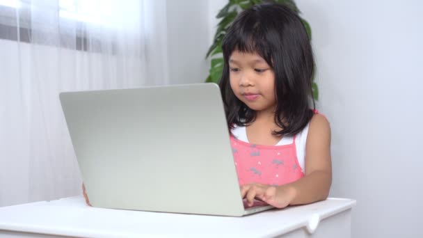 Glücklich ein kleines asiatisches Mädchen, das zu Hause online lernt. Konzept der Online-Bildung in COVID-Pandemiesituation und Technologie für die Bildung im Internet — Stockvideo