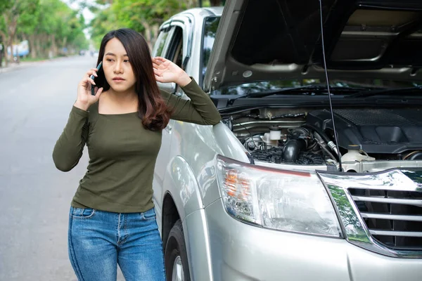 怒っているアジアの女性と路上で車の故障後の支援を求める携帯電話を使用しています 車両エンジンの問題や事故や専門の機械工からの緊急支援の概念 — ストック写真