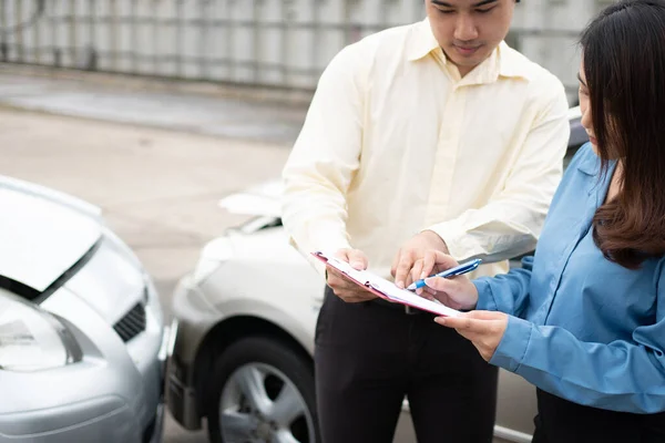 アジアの女性ドライバー事故後のレポート請求書に損傷した車や顧客をチェックするための保険代理店に相談してください 交通事故の概念 — ストック写真