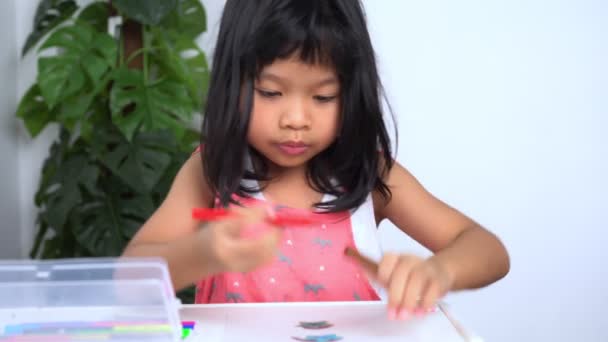 Nettes Kindheitsmädchen Künstler spielt allein Zeichnung Malbild, und das Lernen Schreiben Mathe Hausaufgaben zu Hause am Tisch sitzen, Kinder Grundschulkonzept — Stockvideo