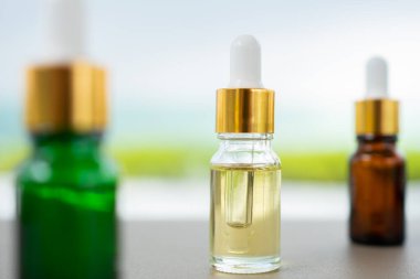 Masanın üzerinde çok renkli cam şişeler var. Aroma yağı, kozmetik ve güzellik kavramı.