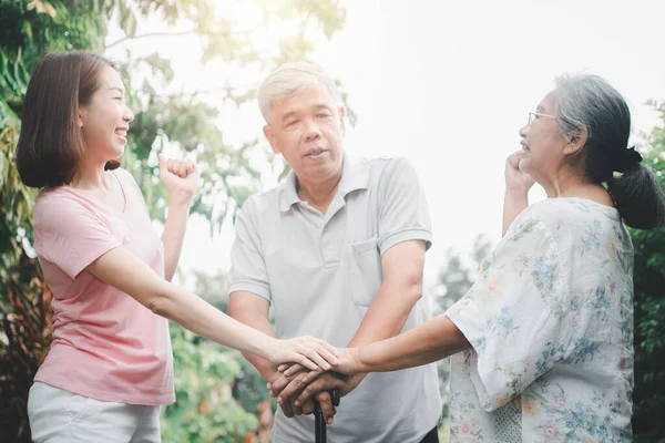 Happy family walking together in the garden. Old elderly using a walking stick to help walk balance. Concept of  Love and care of the family And health insurance for family