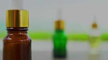Masanın üzerinde çok renkli cam şişeler var. Aroma yağı, kozmetik ve güzellik kavramı.