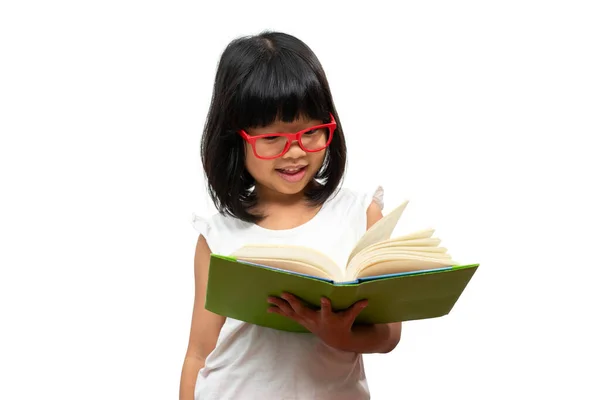 快乐的亚洲学龄前小女孩 戴着红色的眼镜 手里拿着一本关于白色孤立背景的绿皮书 学童的概念以及小学和学前教育 家庭学校的教育 — 图库照片