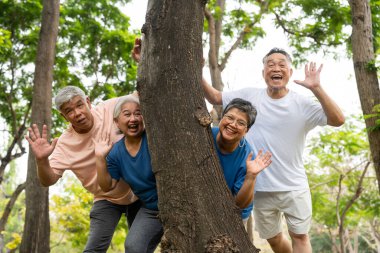Dört yetişkin, açık hava ortamında keyifli bir anın tadını çıkarıyor. Gülüşleri ve gevşemeleri arkadaşlık, aktif yaşlanma ve sosyal bağlantının sonraki yaşamdaki neşesini vurguluyor..