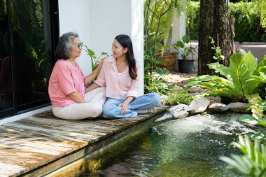 Kızları ve yaşlı anneleri, aile bağlarını güçlendirmek için samimi bir anı paylaşıyorlar. Bakıcı, sevgi ve destek sunuyor. İlişkilerini ve paylaşmanın güzelliğini vurguluyor.
