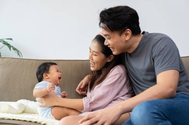 Sevgi dolu bir ebeveyn bebeğini kucaklar, sıcaklığını ve masumiyetini derin bir bağ anında paylaşır. Bu mutlu aile ebeveynliğe değer veriyor, ebeveynliğin güzelliği ile ilişkilerini güçlendiriyor.