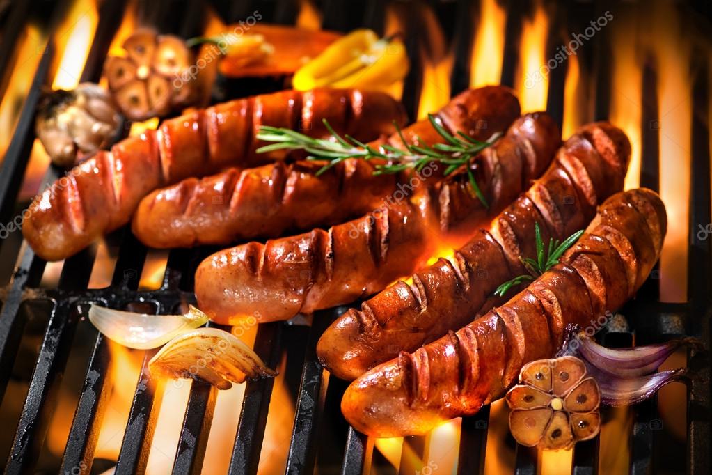 Sausages on the barbecue grill with flames Stock Photo by ©alexraths  101170148