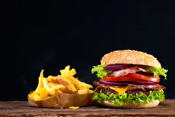 Delicious hamburger on wooden table — Stock Photo, Image
