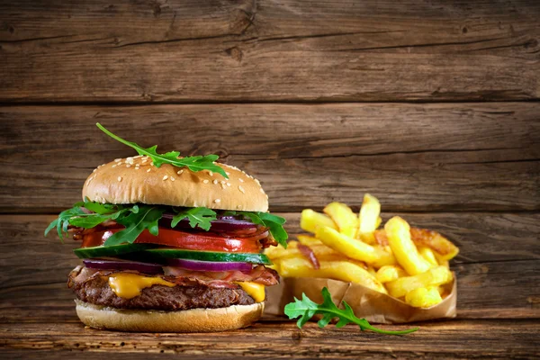 Delicioso hambúrguer na mesa de madeira — Fotografia de Stock