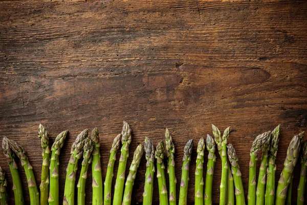 Asparagi freschi su fondo di legno — Foto Stock