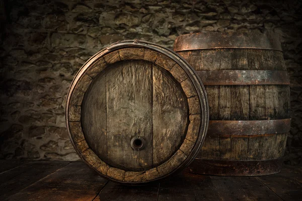 Old oak barrels on blurred cellar wall — Stock Photo, Image