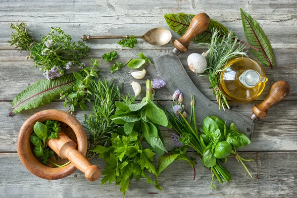 Ervas frescas e especiarias na mesa de madeira — Fotografia de Stock