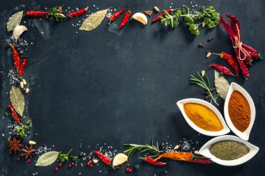 Otlar ve baharatlar siyah taş zemin üzerine