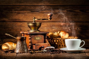 Ahşap arka planda kahve ve kruvasan.