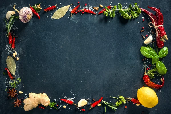 Herbs and spices over black stone background — Stock Photo, Image