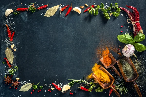 Kruiden en specerijen over zwarte stenen achtergrond — Stockfoto