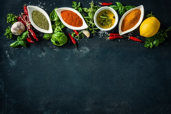 Herbs and spices over black stone background — Stock Photo, Image