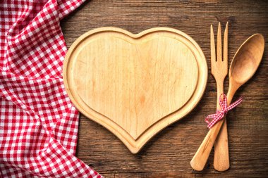 Heart shaped cutting board with a red checkered tablecloth clipart