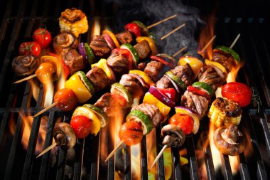 Meat kebabs with vegetables on flaming grill clipart