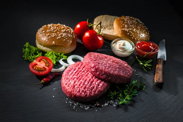 Hamburger için diğer malzemelerle ham sığır köftesi — Stok fotoğraf