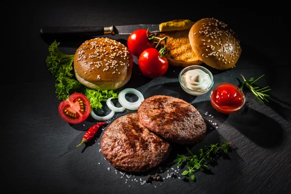 Hamburguesas a la parrilla con otros ingredientes para hamburguesas —  Fotos de Stock