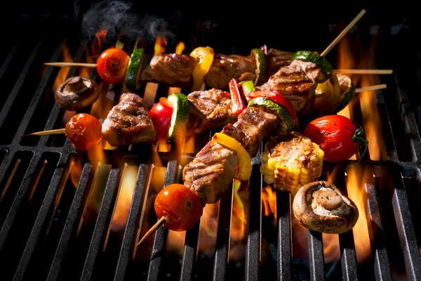 Kebabs de carne com legumes na grelha flamejante — Fotografia de Stock