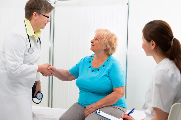 Médico estrechando las manos con el paciente —  Fotos de Stock