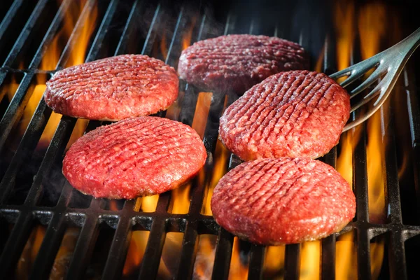 Beef hamburger patties sizzling on the barbecue — Stock Photo, Image