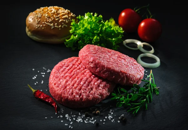 Galettes de boeuf cru avec d'autres ingrédients pour hamburgers — Photo