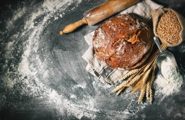 Un ve tahılla süslenmiş köy sofrasında taze pişmiş geleneksel ekmek.
