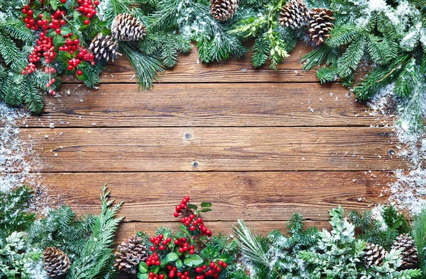 木版上のモミの枝 ホリーと雪とクリスマスと新年の背景 — ストック写真