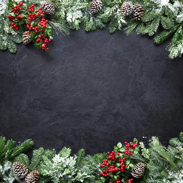 モミの枝 ホリーと暗い石板の雪とクリスマスと新年の背景 — ストック写真