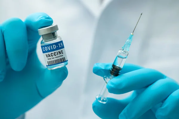 医护人员手中的Covid 19疫苗 医生拿着注射器和瓶装水 用疫苗治疗头孢病毒 电晕病毒治疗 注射概念 — 图库照片