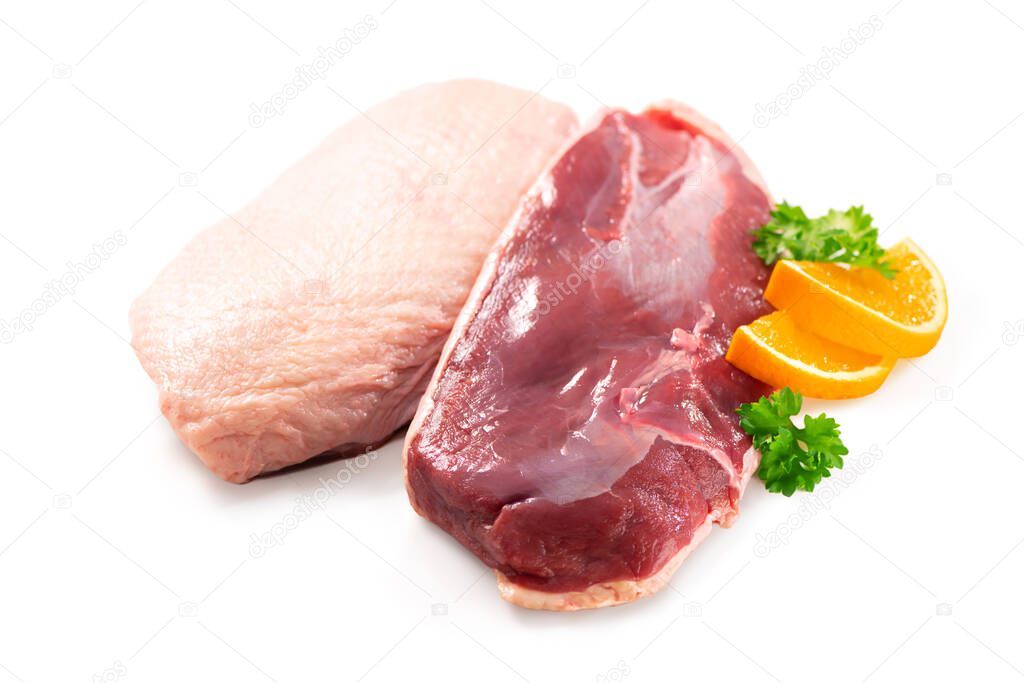 Raw duck breast pieces garnished with parsley and orange slices isolated on white background