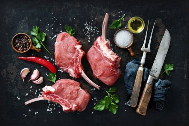 Köy arka planında malzemeli çiğ et pirzolası, üst manzara. Fransız Rafları eti.