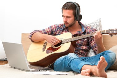 Akustik gitar çalan müzisyen.