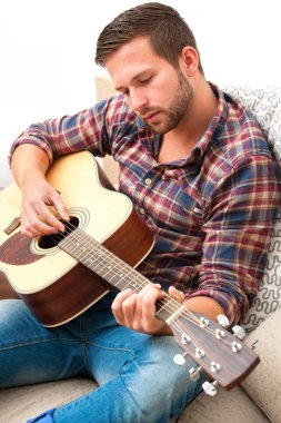 Akustik gitar çalan müzisyen.